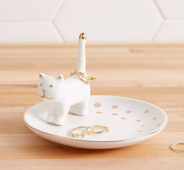 A smooth little saucer-like dish with a tiny cat figure on it