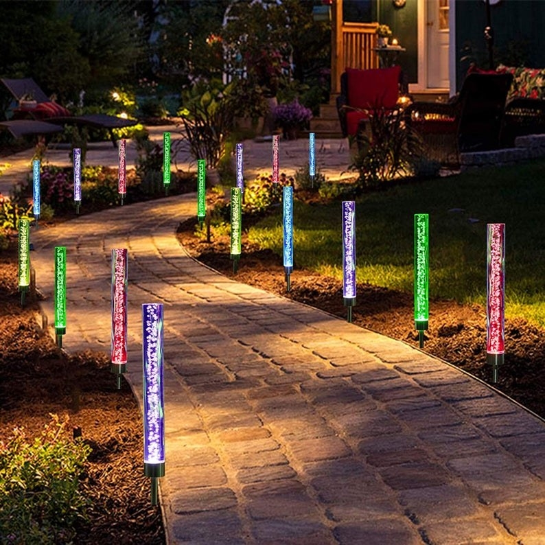 Solar powered lights in different colors lighting up a pathway 