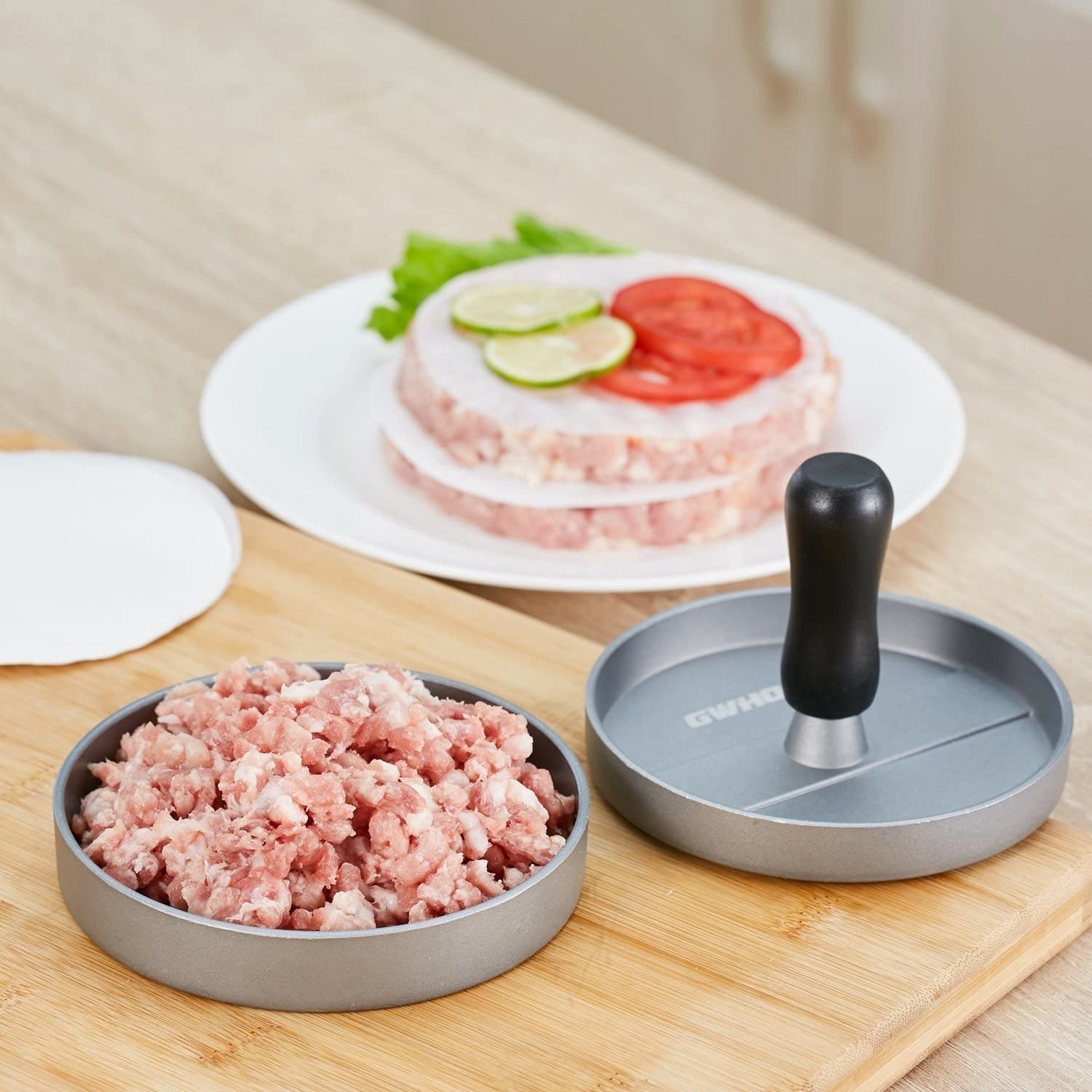 A hamburger press with meat in it