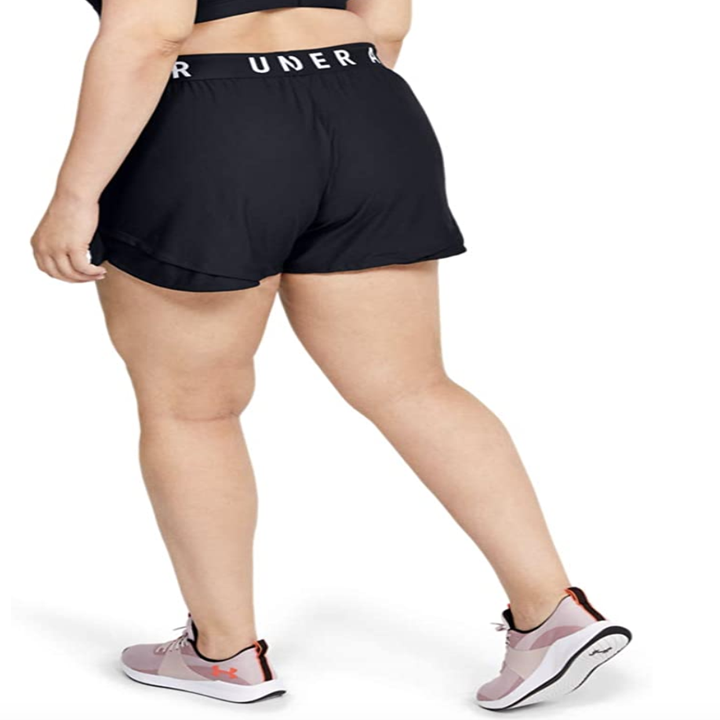 The model showing the back of the shorts where it says "Under Armour" on the elastic waistband