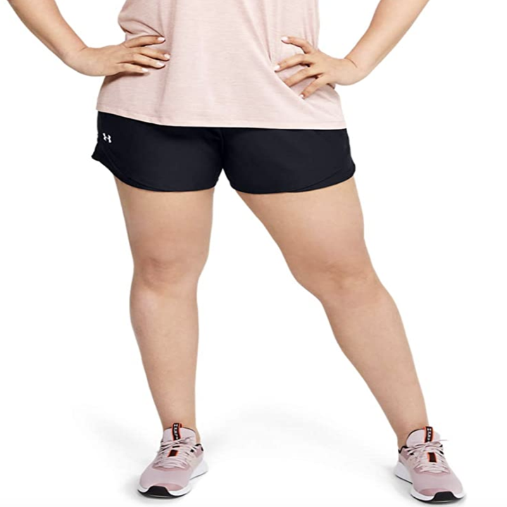 A model in black elastic workout shorts that fall above mid thigh 