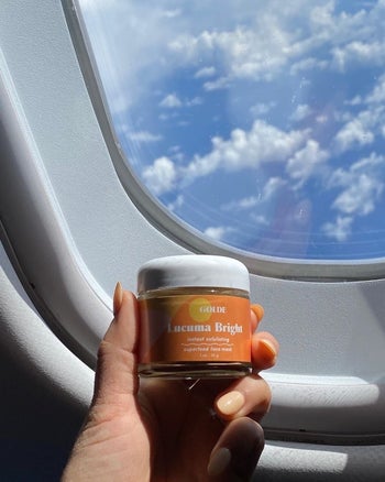 hand holds container in airplane