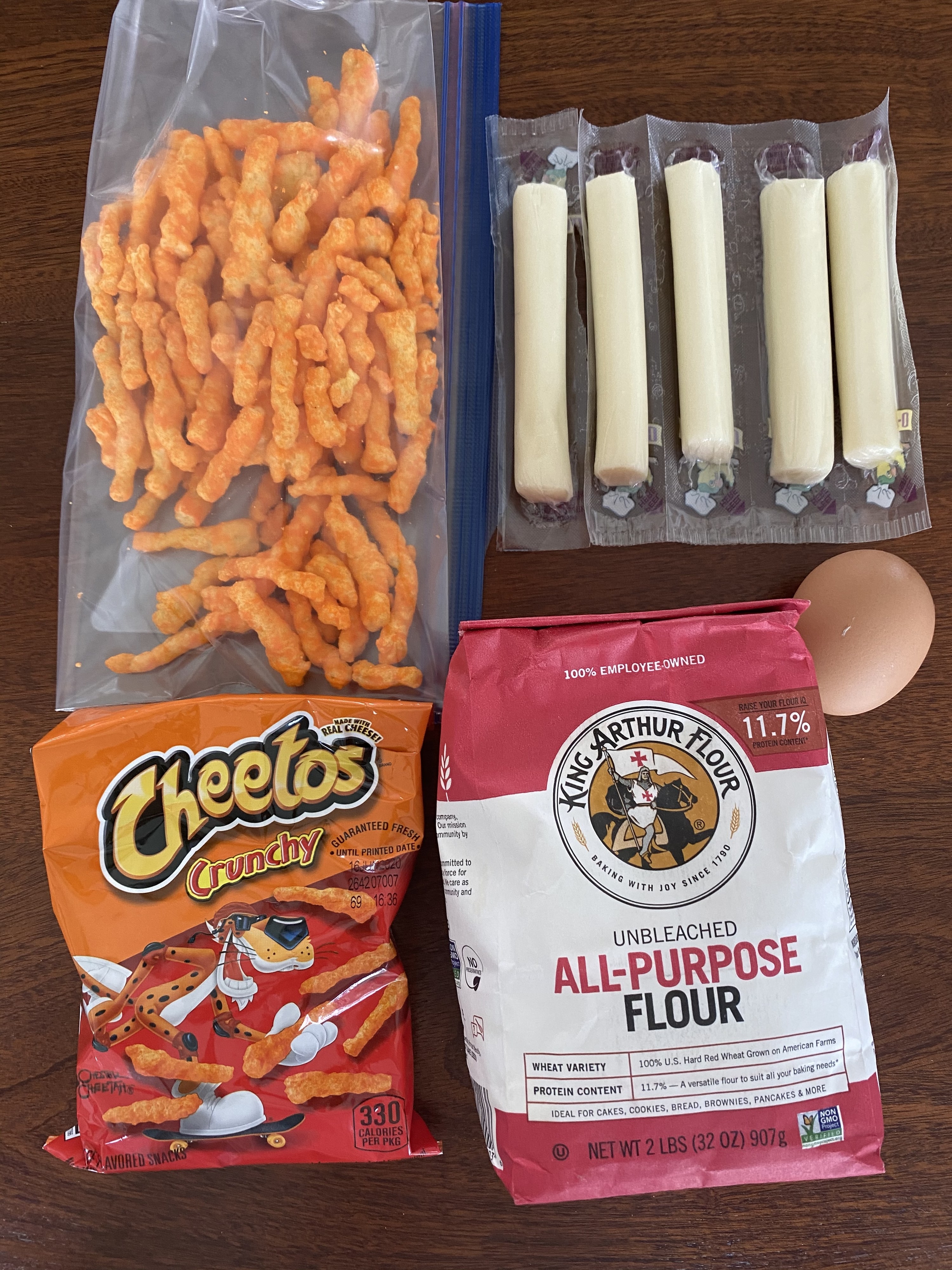 Ingredients for Cheeto-crusted mozzarella sticks on a countertop 