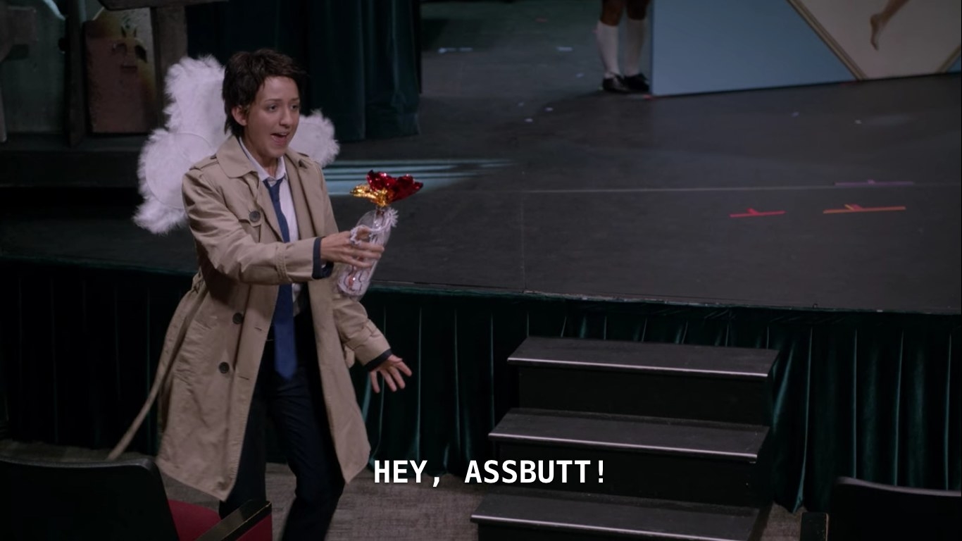 Taking place in an auditorium, a teenage girl dressed as Castiel, in fake angel wings, rehearses the scene from Swan Song, by throwing a fake Molotov cocktail at no one in particular.