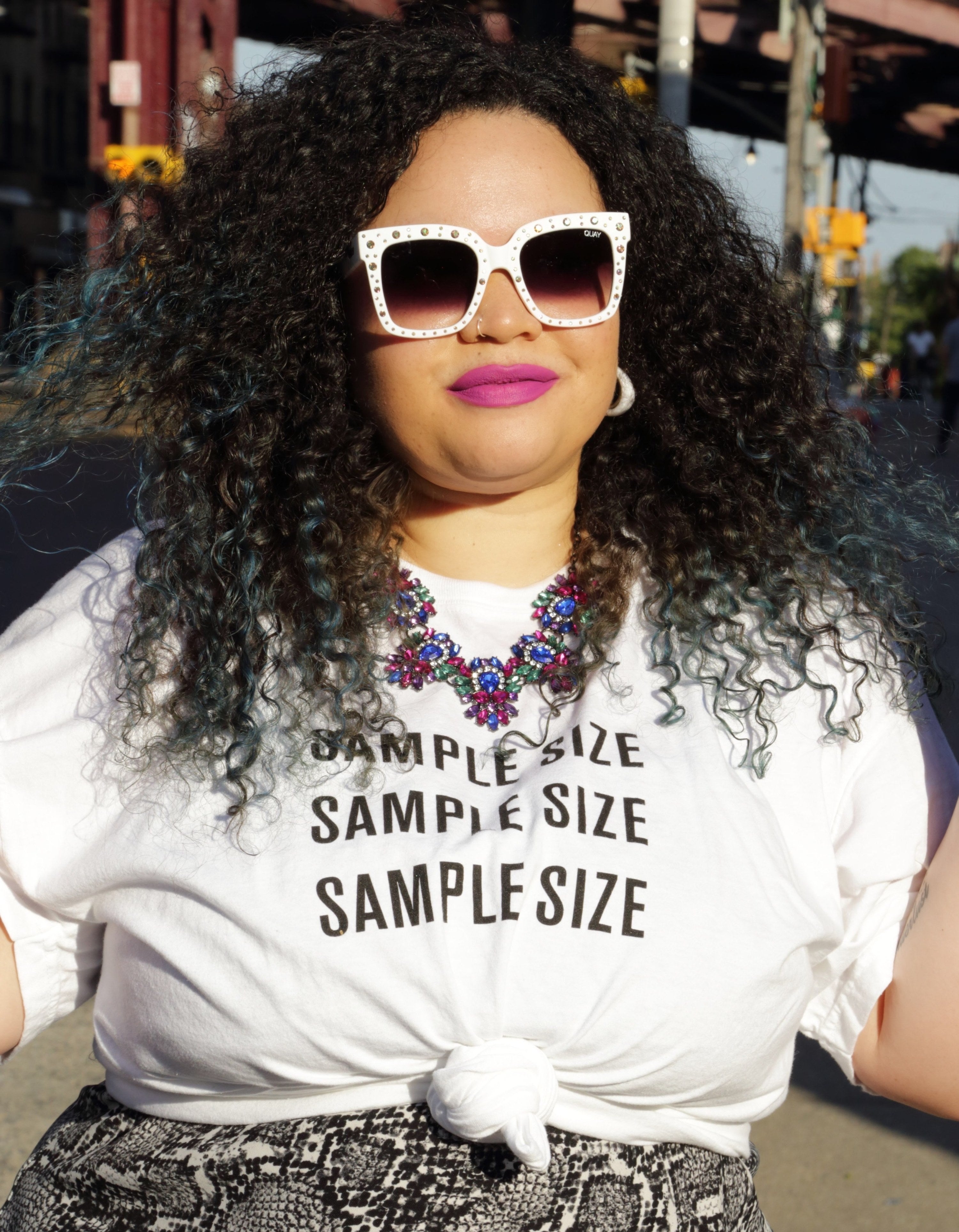 BuzzFeed Shopping editor wearing the white T-shirt with black letters reading "sample size" three times in a row