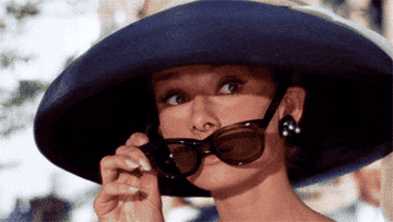 Holly Golightly from &quot;Breakfast at Tiffany&#x27;s&quot; slipping on black shades
