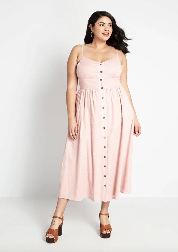 A model in a pale pink dress with straps