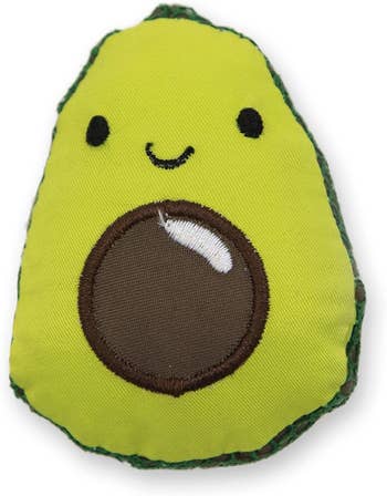 an oblong avocado with a brown pit in the middle and a tiny smiley face on top to personify it