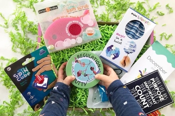 Featured sensory items and child&#x27;s hands reaching for regulation putty