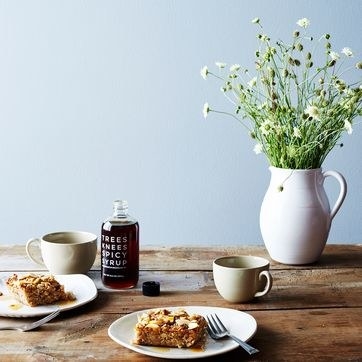 breakfast table setup with coffee cake on plates and spicy syrup bottle