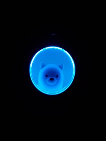 the humidifier as seen in the dark with a light up blue window and dog inside 
