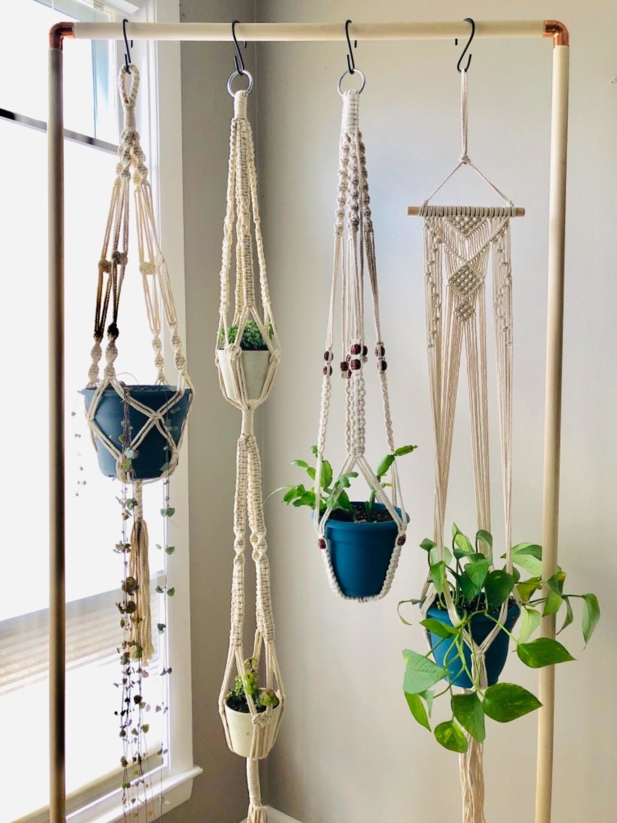 Review photo of the macrame holders and planters hanging from a garment rack