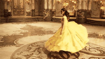 Emma Watson as Belle, twirling in her iconic golden ballgown