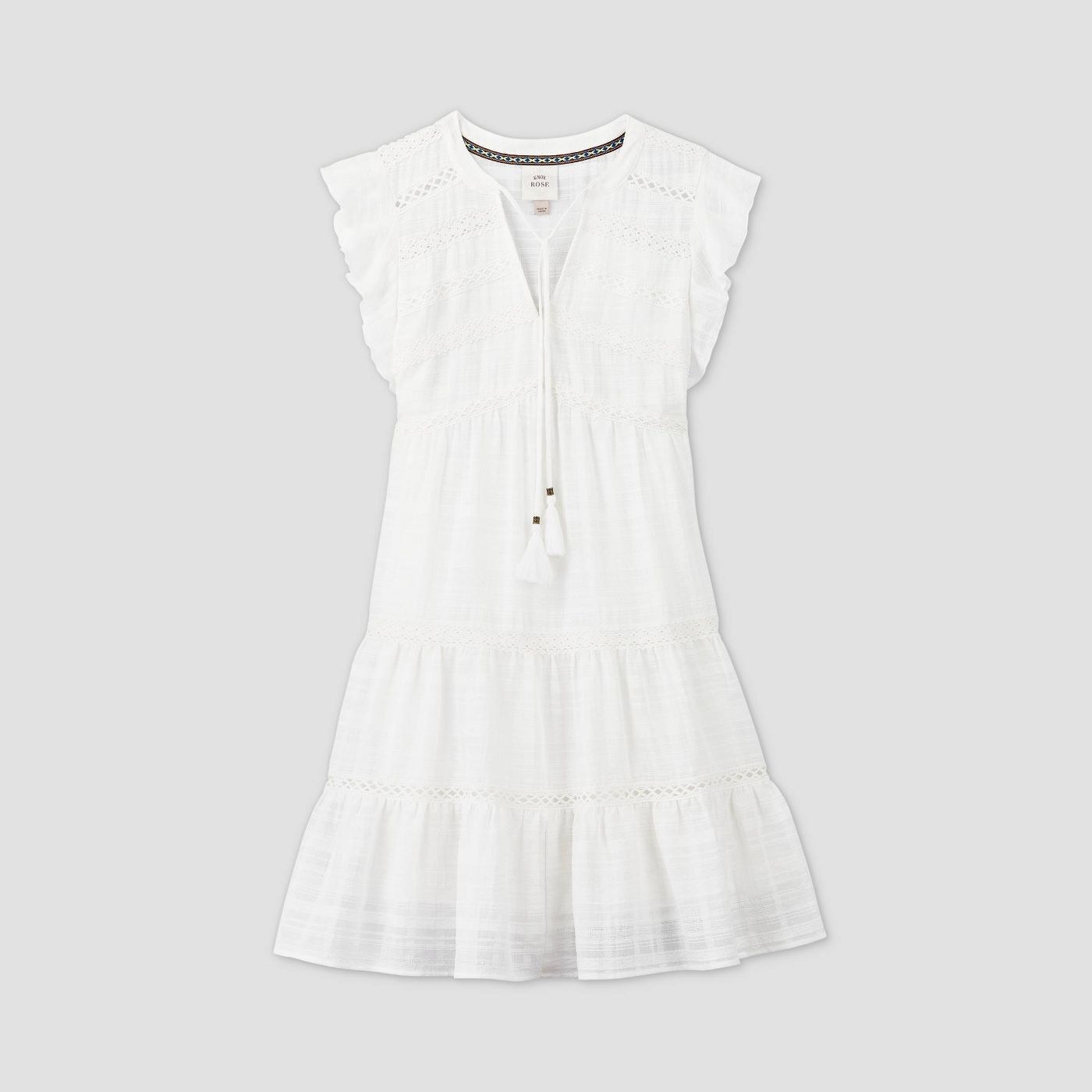A white tiered eyelet dress with tassel ties at the collar
