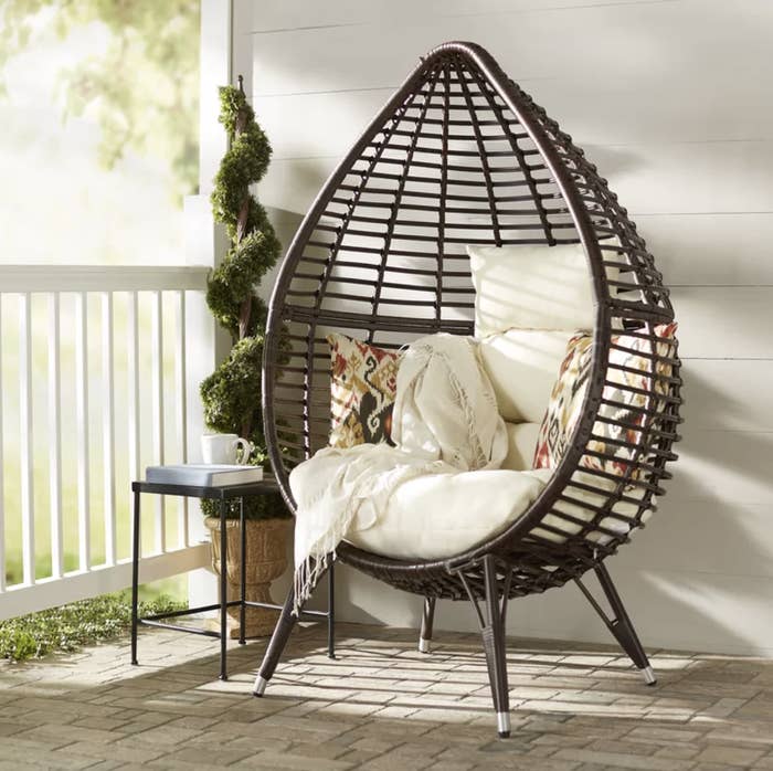the wicker teardrop chair with pillows 