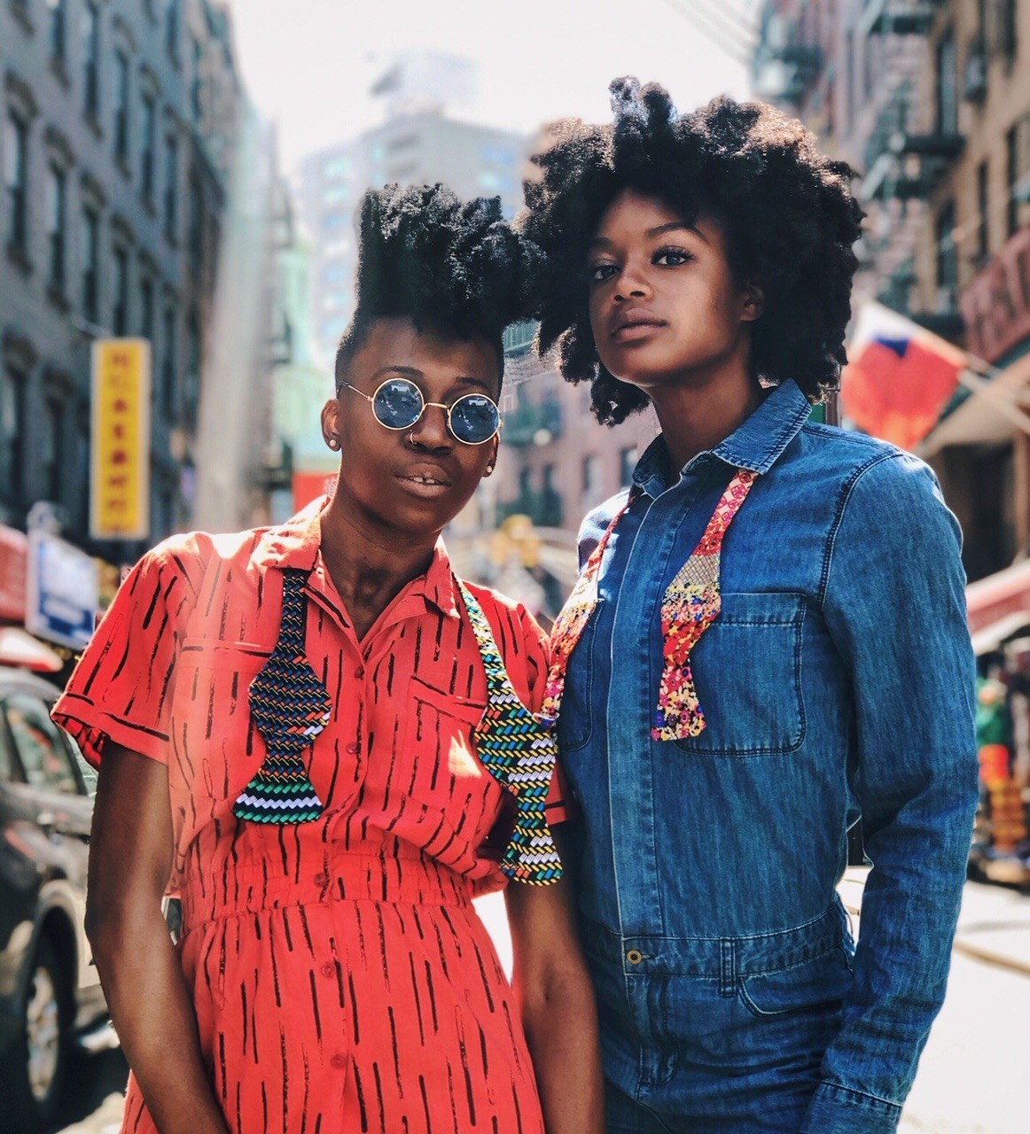 Two models wearing colorful, printed neck straps 