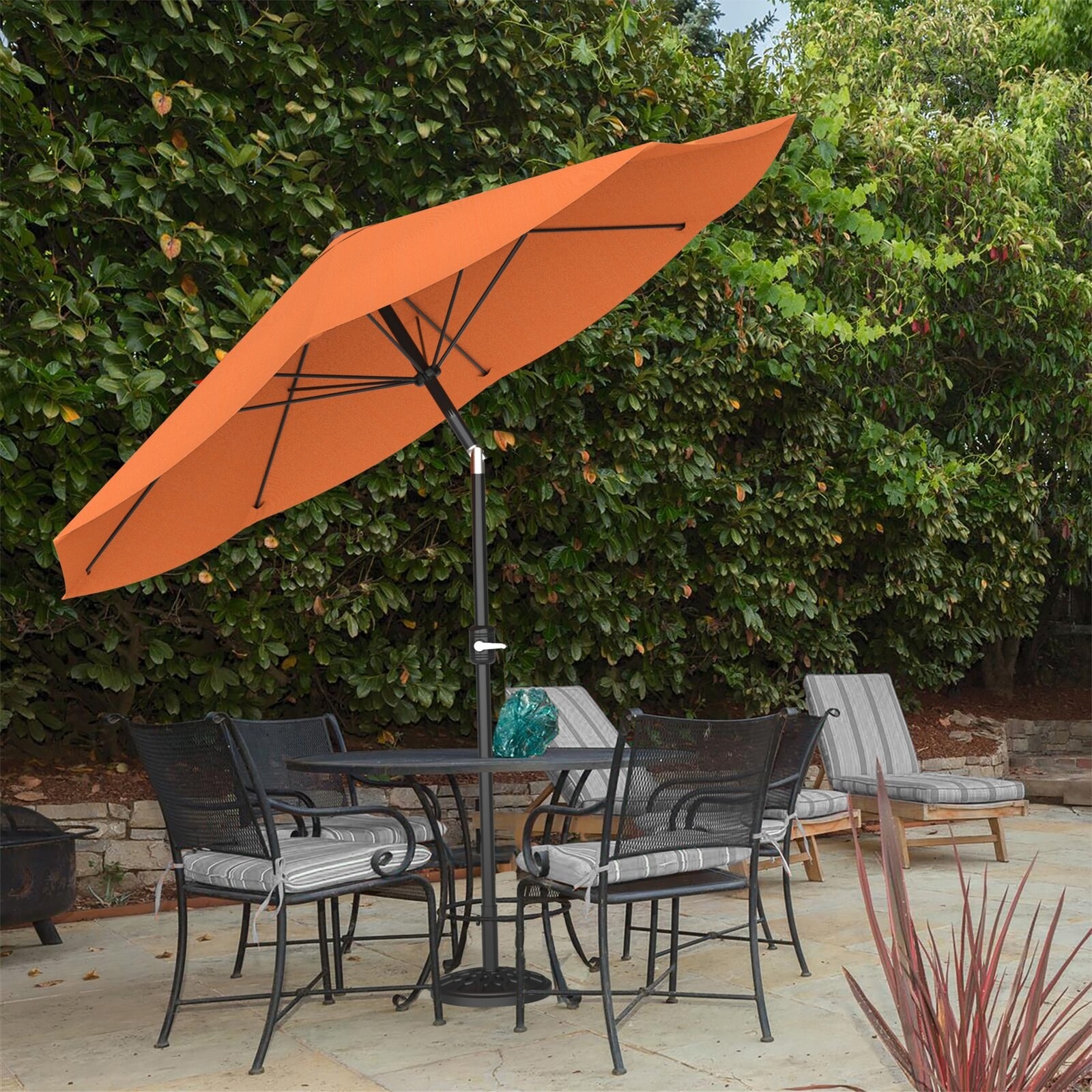 The adjustable umbrella attached to an outdoor dining table