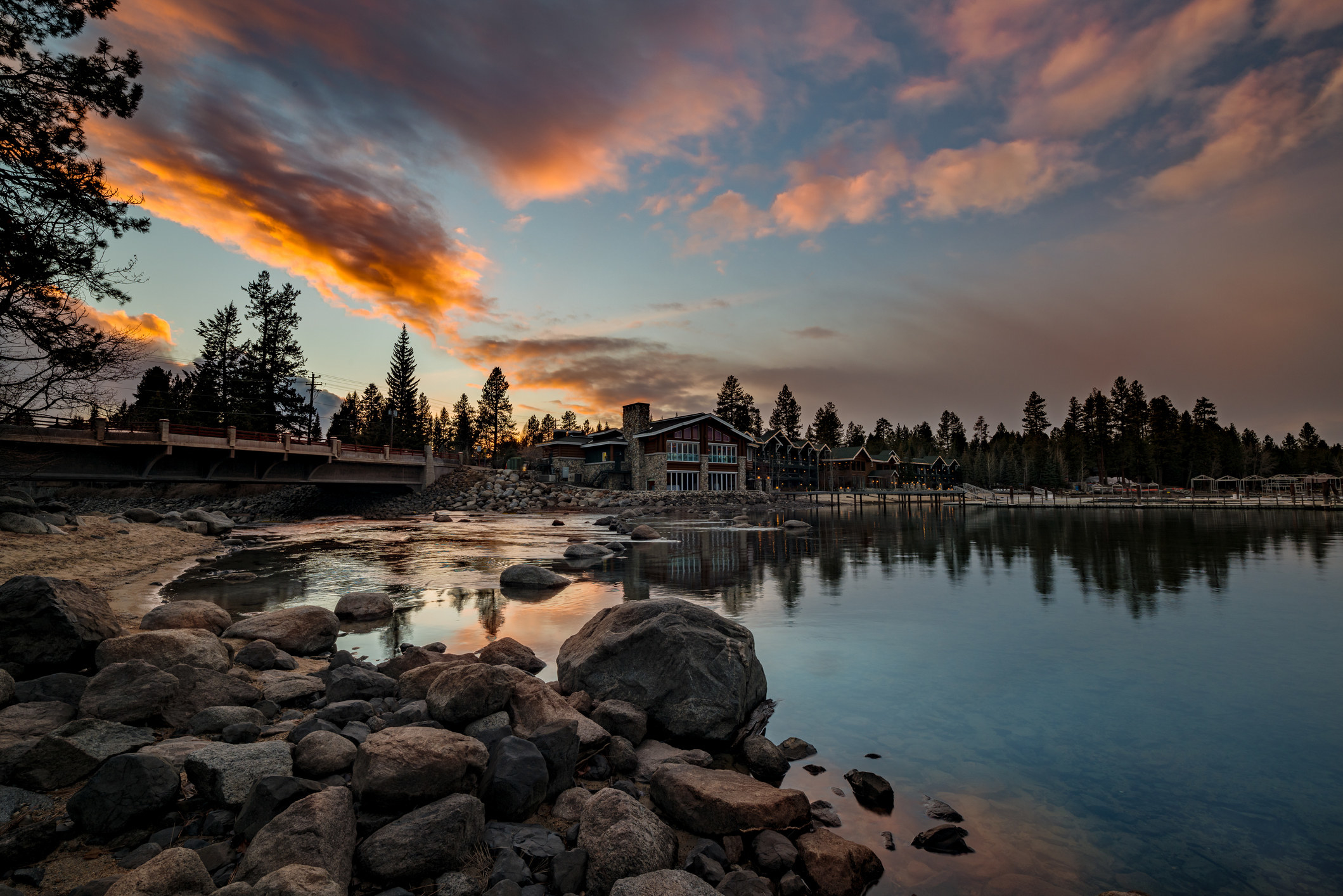 Sunset on Payette Lake with hotel and cloud reflections in the water shoreline