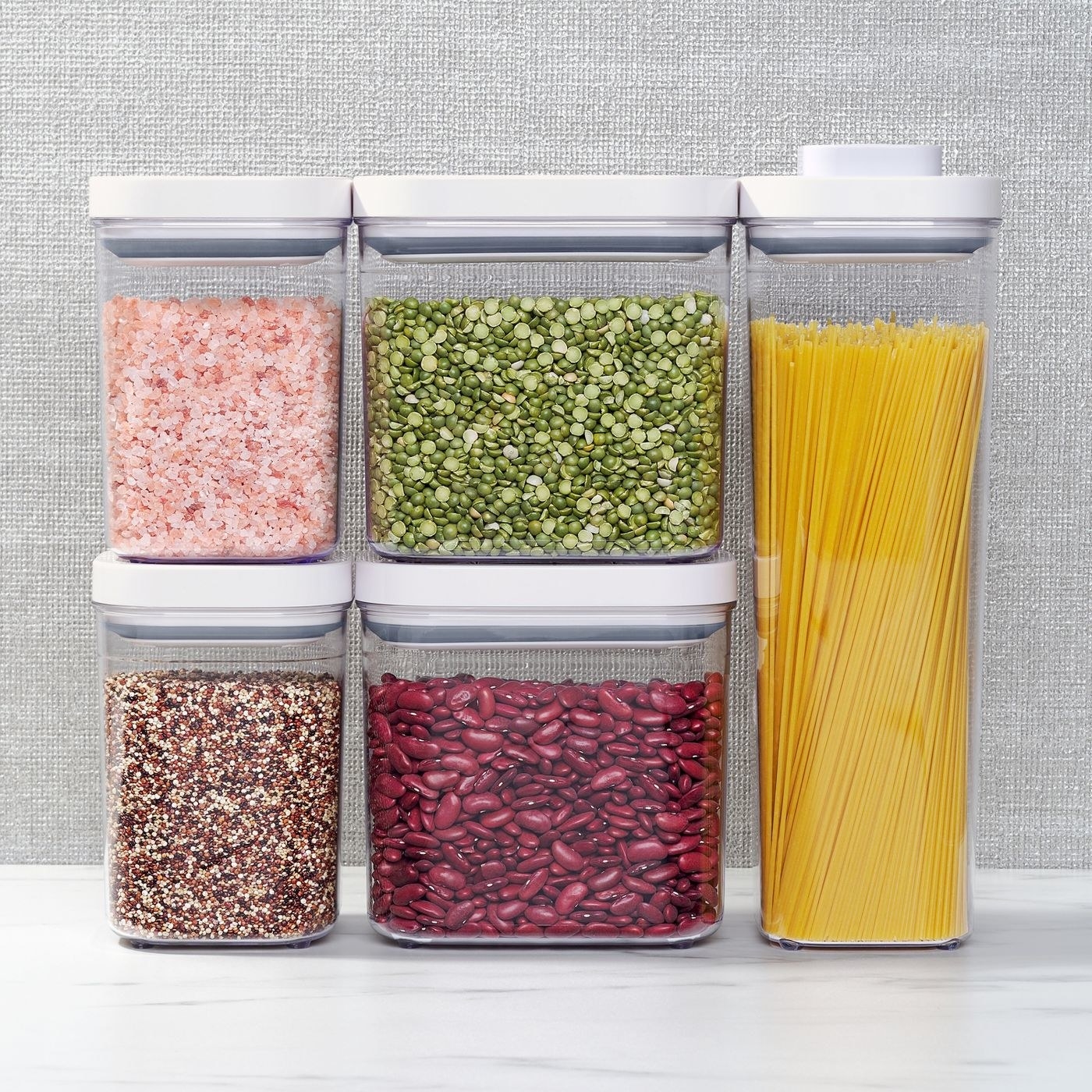 five pop containers in different sizes with white lids