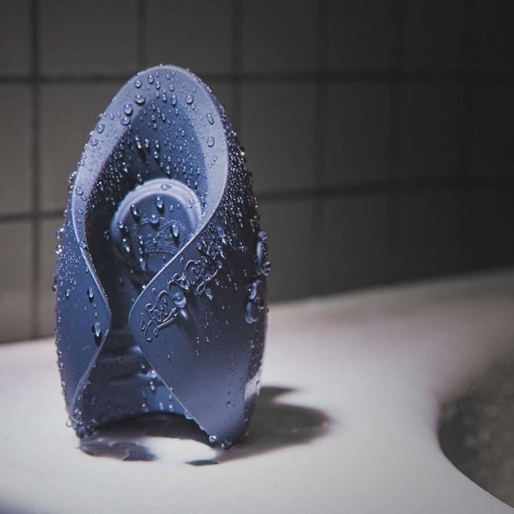 the penis vibrator on the edge of a bathtub wet to show it's waterproof