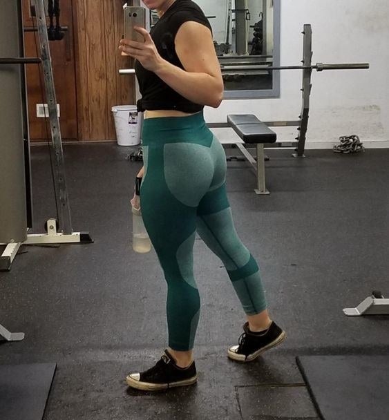 Reviewer wearing the two-toned light and dark green leggings, and showing the full-coverage back 
