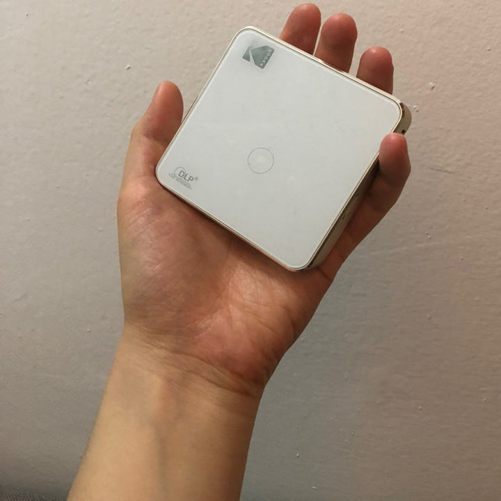 hand holding white palm-sized square 