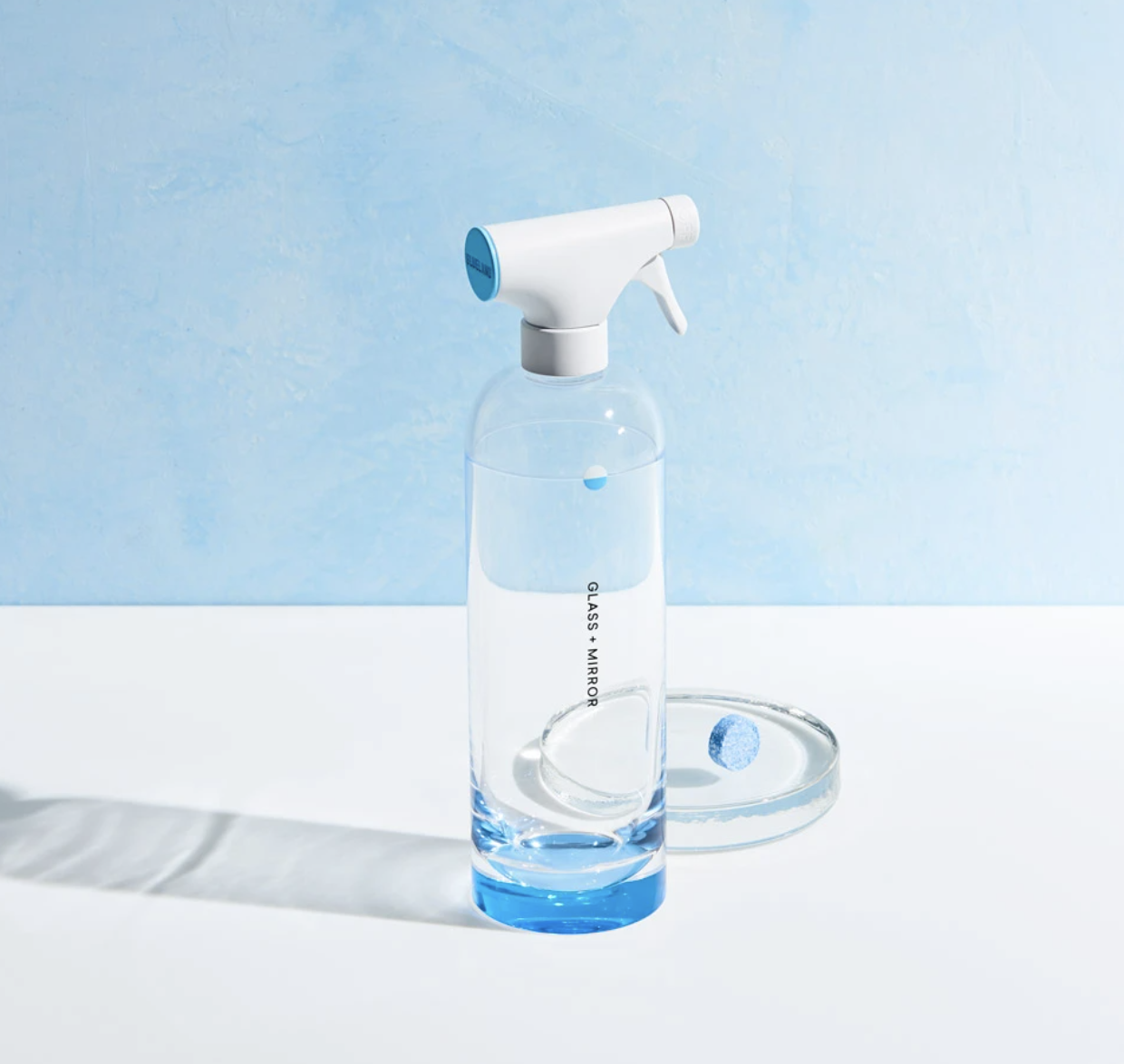 A Blueland Reusable Glass + Mirror Cleaning Bottle filled with a clear liquid