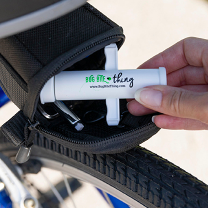 A product shot of the finger-length suction tool being placed inside a bike pack