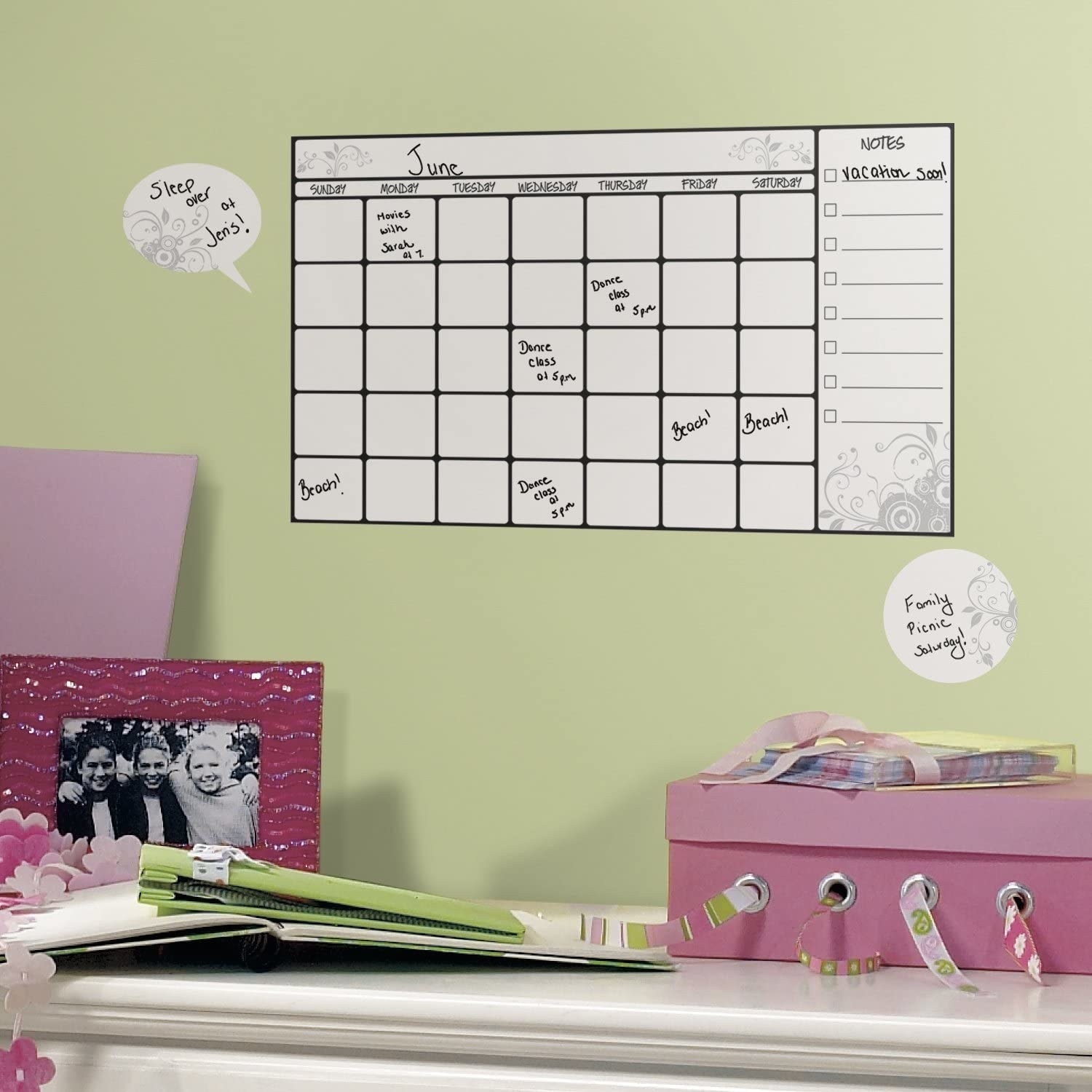 A dry-erase decal calendar on a wall with text written on the days in marker