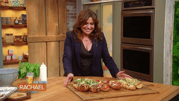 Rachel Ray excitedly points to food on a tray