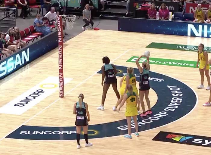 A netball player taking a shot from inside the two-point zone