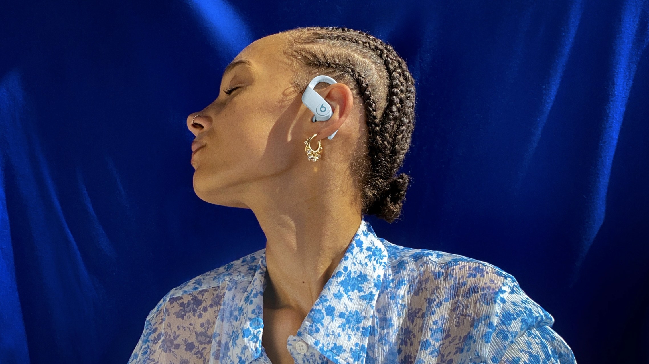 A model with a pair of white Beats wireless headphones in their ears