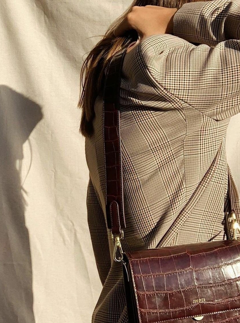 model wearing brown flap bag