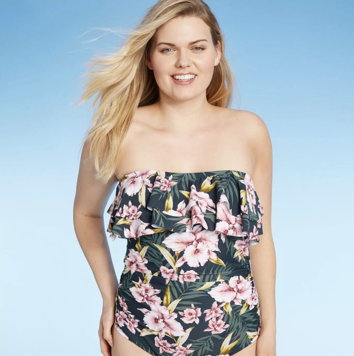 A model in a green one piece with pink and yellow floral detail 