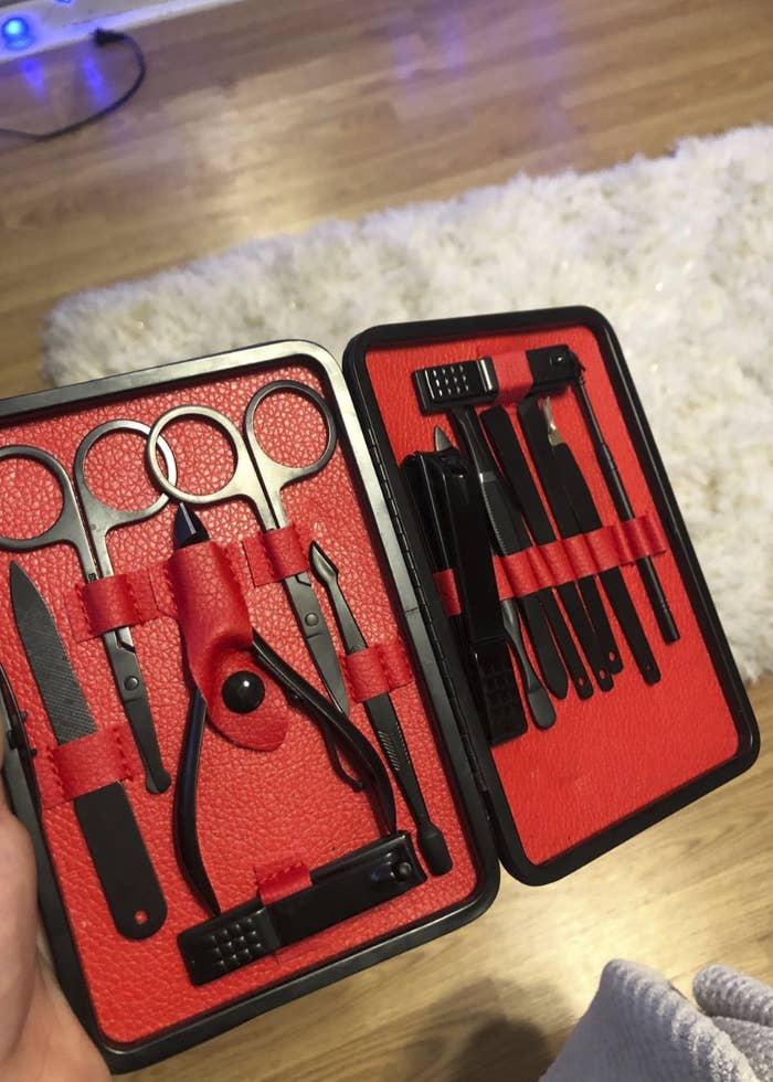 The kit unzipped and open. It takes on the shape of an open book and inside, the nail tools are tucked into tiny leather slots