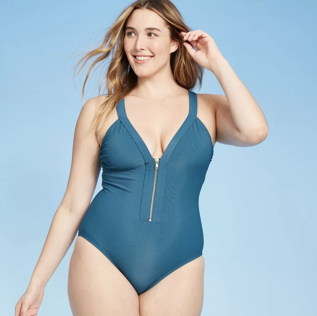 A model in a blue one piece with a zippered top 