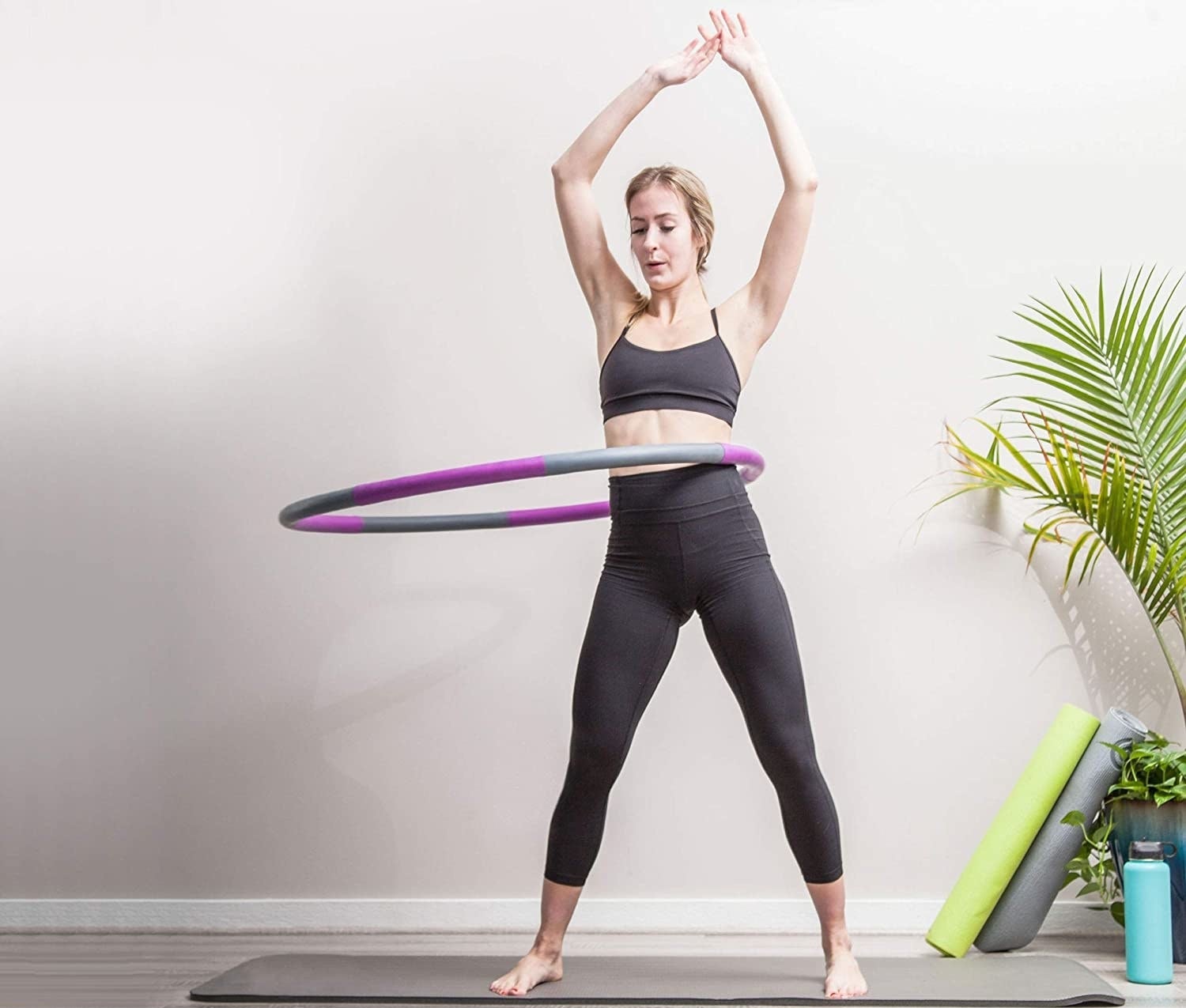 A model using the hoola hoop in a home gym