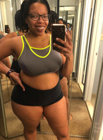 Reviewer wears lime green and gray supportive sports bra with black workout shorts