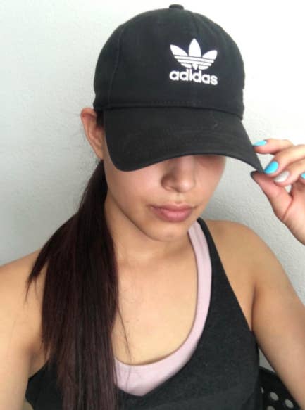Reviewer wears pink adidas baseball cap with a white T-shirt