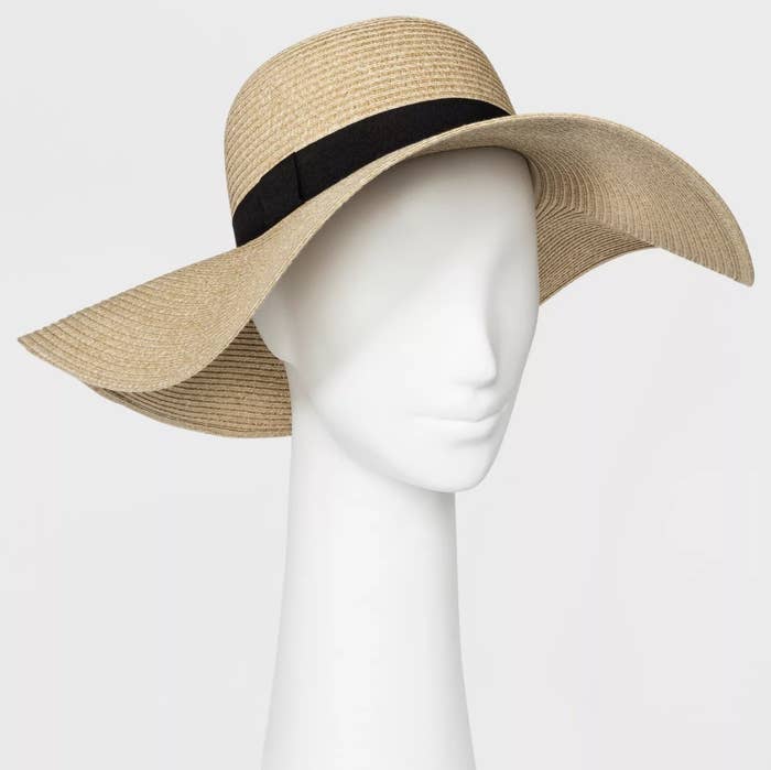 A floppy straw hat with a black ribbon at the brim 