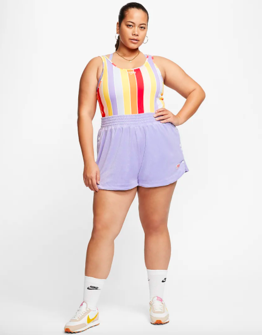 Model wears striped Nike bodysuit with purple running shorts