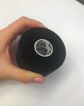 Reviewer holds roll of black athletic tape in their hand