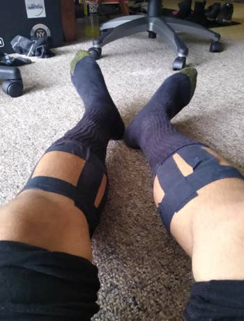 Reviewer wears black athletic tape around their calves before a workout