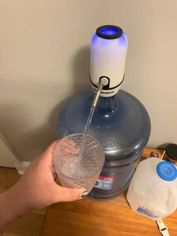 Reviewer using the dispenser to pour water from the jug, hands-free