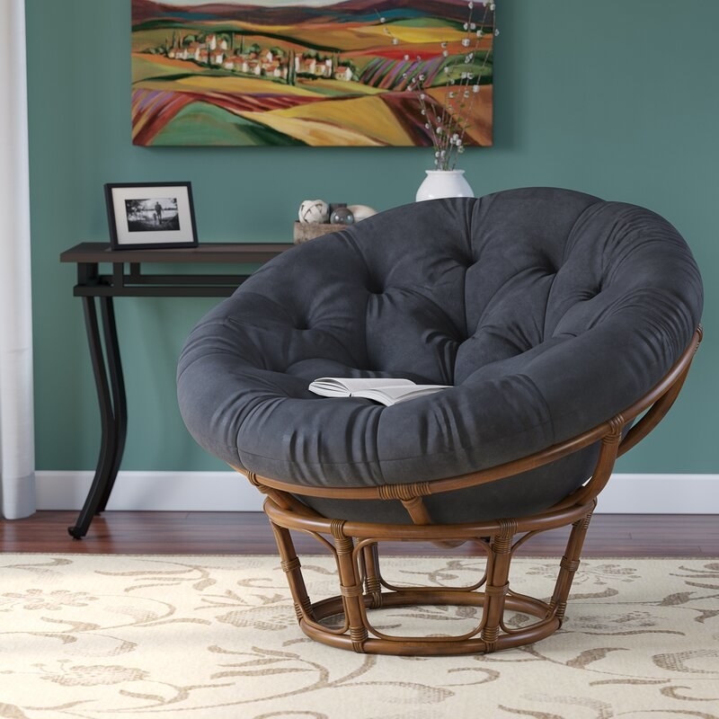 a thick, black microfiber circular cushion inside a circular wicker platform