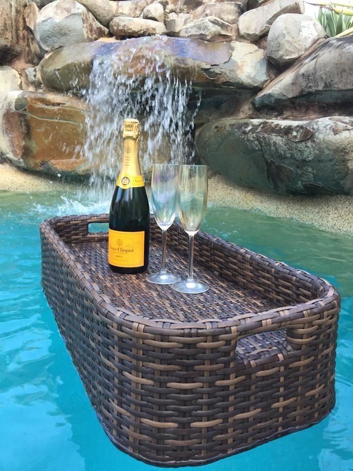 The basket keeping a bottle of wine and two glasses afloat in water