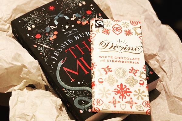 A book and a bar of white chocolate with strawberries
