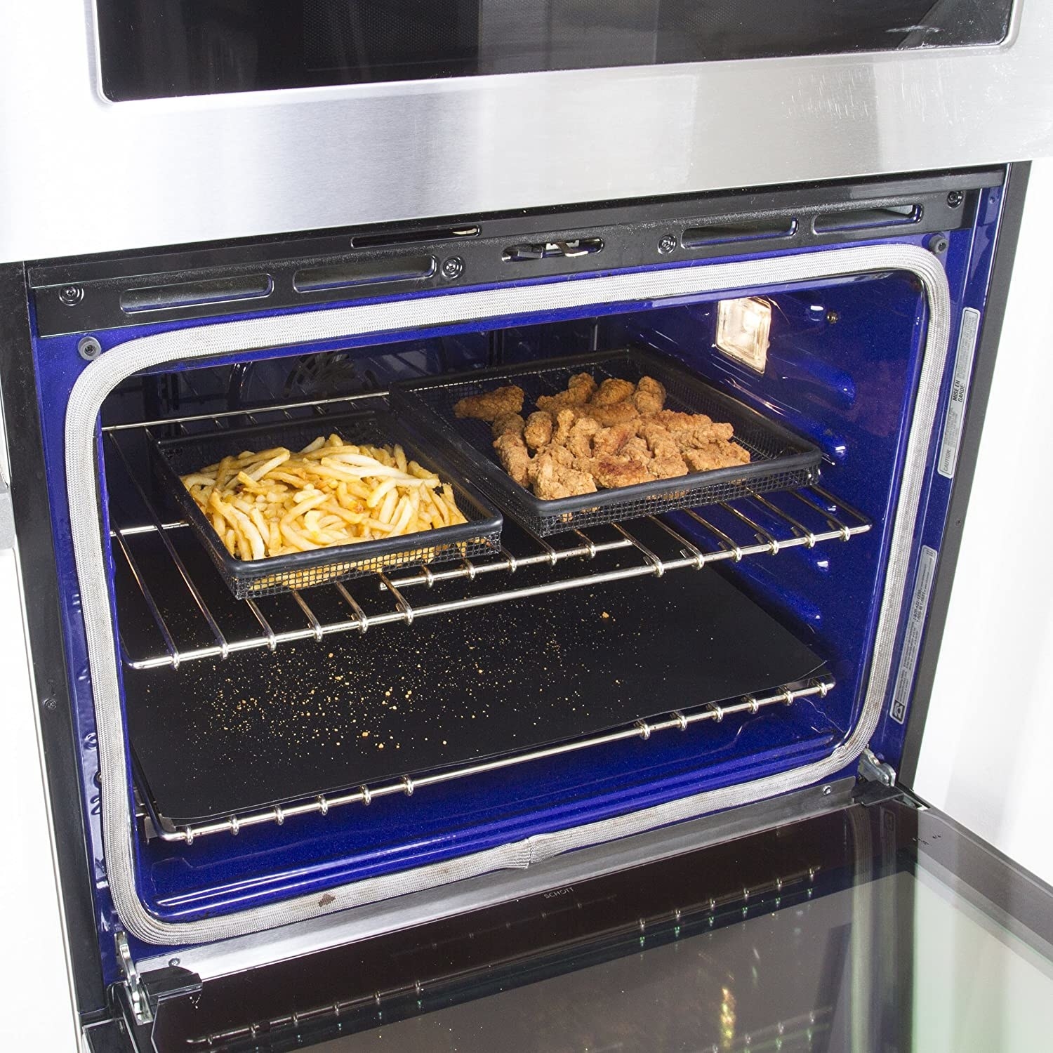 An oven with a liner sheet on the bottom catching crumbs