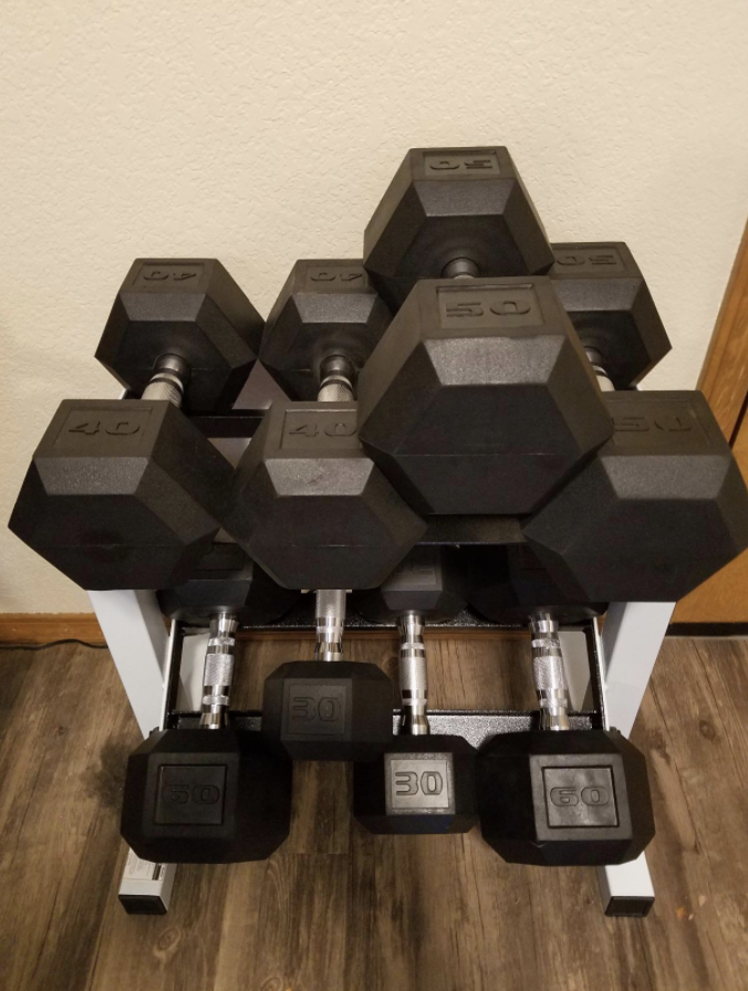 Reviewer uses white two-tier dumbbell rack with black 30 and 40-pound weights in their home