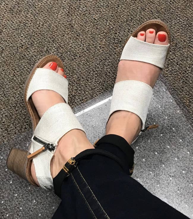 reviewer wearing the heels with white canvas straps and size zipper